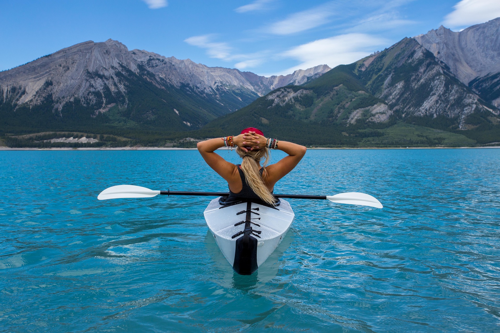 Une femme faisant du kayak sur un lac bleu turquoise