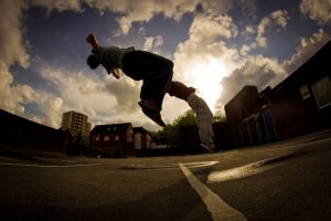 Traceurs qui pratiquent le parkour en faisant un backflip sans obstacle