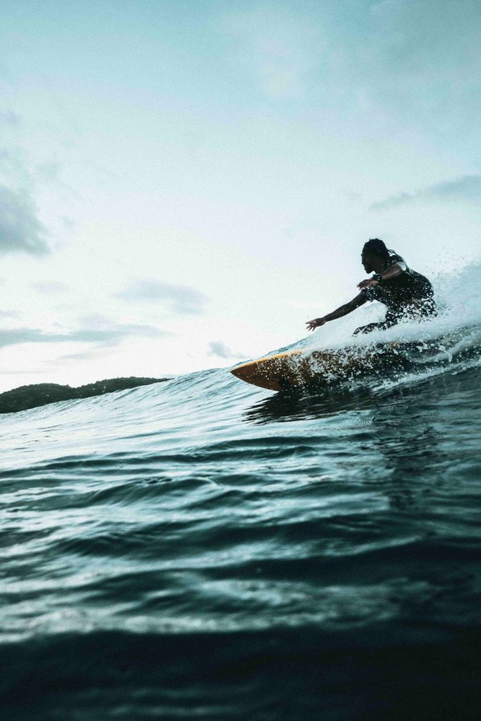 Une silhouette surfant sur une mer grise